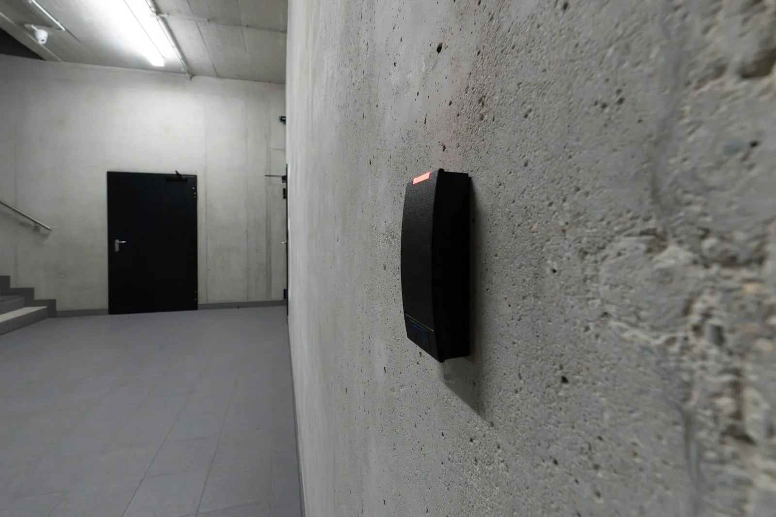 An access card reader beside a door in a stairwell