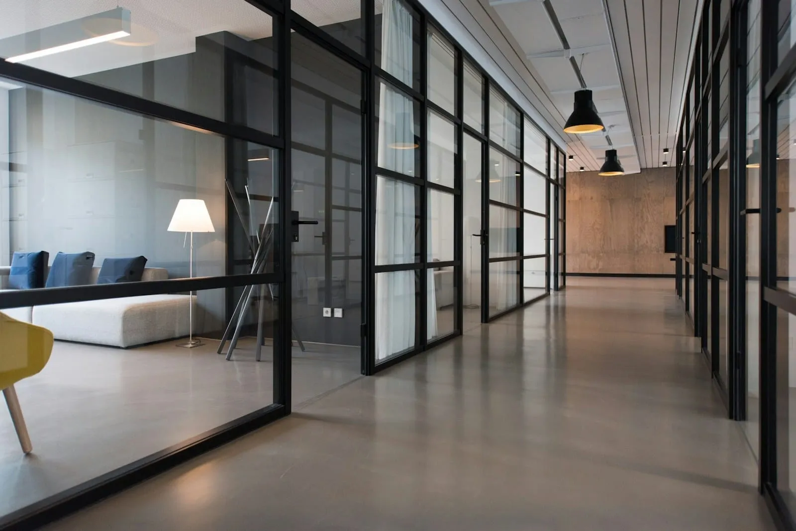 An office hallway between glass panel doors